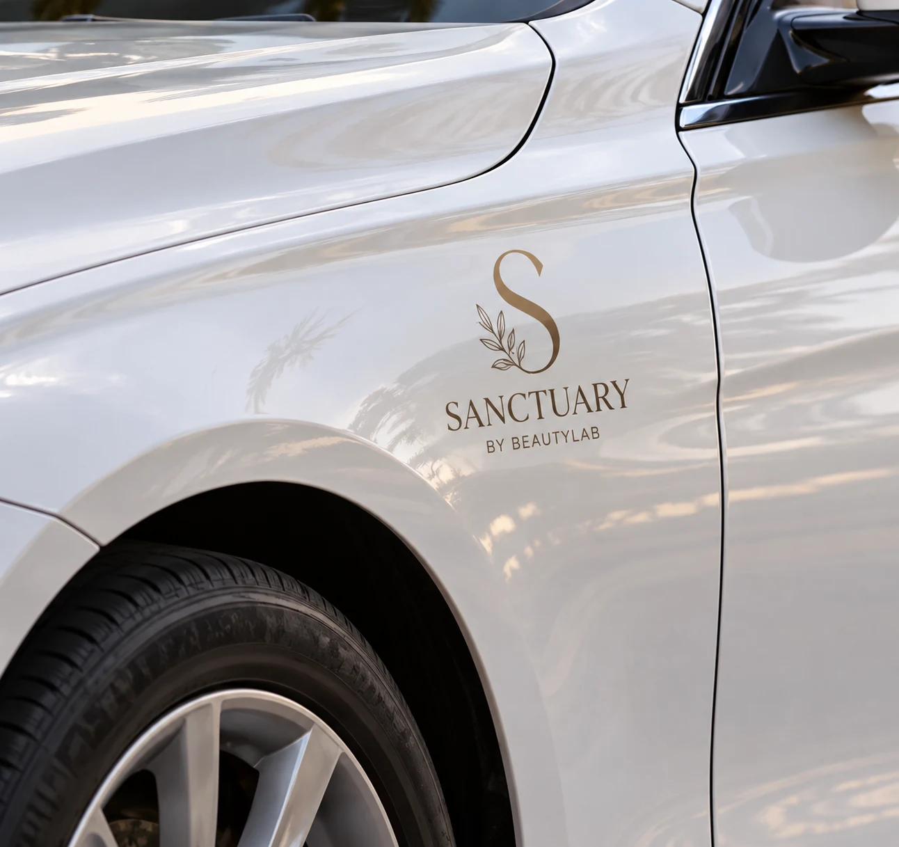 Sanctuary logo on the front fender of the white BMW 320i transfer car